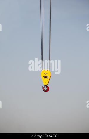 Starke Haken und Umlenkrolle hängen mit 2 Kabel w einen Greifer roten Haken um schwere Dinge zu tragen. Es ist von einem Kran im Himmel baumelt. Stockfoto