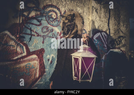 Mann mit Maske Wolf und Lampe mit farbigen Rauch Stockfoto