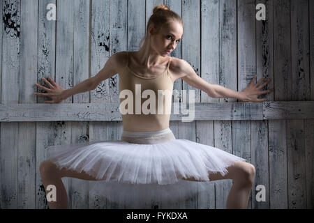 Ballerina, Stand in der Nähe einer Holzwand Stockfoto