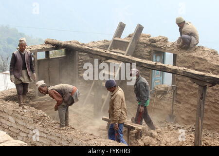 Männer nehmen Sie die übrigen Teile eines Hauses in Ruinen in Bhusapheda, Nepal, 29. März 2016. Viele Personen in den ländlichen Regionen haben keine Mittel für den Wiederaufbau ihrer Häuser im Vergleich zu städtischen Bewohner, die begonnenen Wiederaufbau ihrer Stadtteile und Städte auch ohne staatliche Unterstützung. Eine massive Erdbeben in Nepal am 25. April 2015. Foto: Doreen Fiedler/dpa Stockfoto