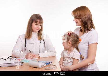 Kinderarzt hört sich die Klagen der das kleine Mädchen und ihre Mutter Stockfoto