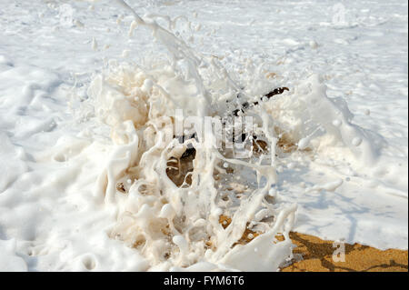 Hohe Wellen an den Felsen der Küste brechen Stockfoto