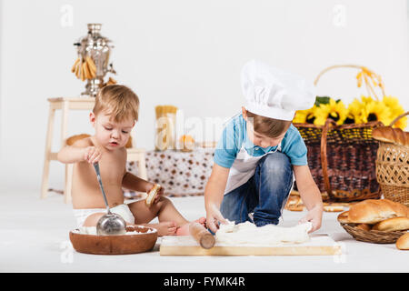 Kleine Mädchen und lustige junge tragen Kochmützen Stockfoto