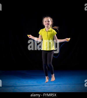 Kleines Mädchen, die gymnastischen Übungen auf schwarz Stockfoto