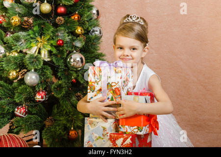 Fünfjähriges Mädchen umarmt Weihnachtsgeschenke Stockfoto