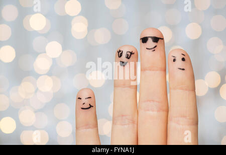 Nahaufnahme von vier Fingern mit Smiley-Gesichter Stockfoto