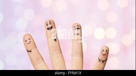 Nahaufnahme von vier Fingern mit Smiley-Gesichter Stockfoto