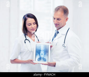zwei Ärzte, die x-ray auf tablet-pc Stockfoto