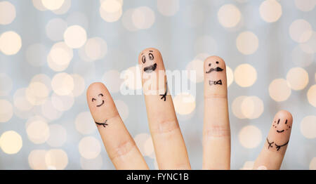 Nahaufnahme von vier Fingern mit Smiley-Gesichter Stockfoto