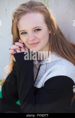 Eine rothaarige Teen außerhalb mit ihre Hände zusammen. Stockfoto