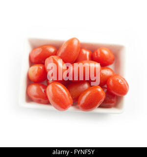 Weiße rechteckige Schale gefüllt mit frischen roten Kirschtomaten von oben auf einem weißen Hintergrund angezeigt Stockfoto