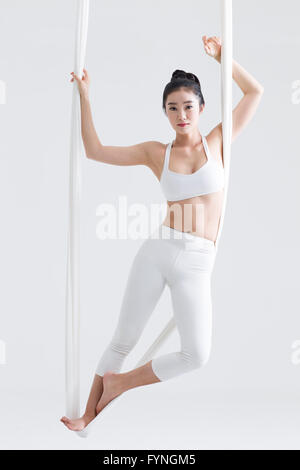 Junge Frau aerial Yoga zu praktizieren Stockfoto