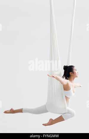 Junge Frau aerial Yoga zu praktizieren Stockfoto