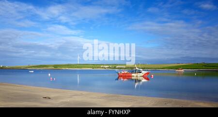 Rote und weiße Fischerboot bei Ebbe auf einer Flussmündung auf Orkney, Schottland Stockfoto