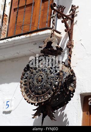 Rostige kreisförmige kunstvolle Schmiedearbeiten Laterne hängen vor einem Haus in Sitges, Spanien Stockfoto