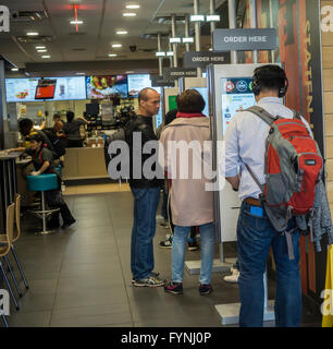 American Diner Bestellung auf "Erstellen Sie Ihren Geschmack" Kioske bei McDonalds am Dienstag, 26. April 2016 in New York. Die interaktive iPad-ähnliche Digitalanzeigen erlauben es Kunden, ihre Bestellung mit Belag, neue Soßen usw. anpassen. Die McDonald's Corp. berichtete kürzlich eine 35 % Zunahme der Gewinne, die direkt auf ihre "All Day Breakfast" Förderung zurückgeführt werden. . (© Richard B. Levine) Stockfoto