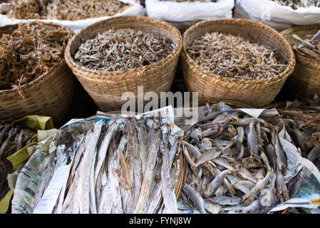 Getrocknete gesalzene Fische in geflochtenen Bambuskörben Nyaung U Markt Myanmar | NYAUNG-U, Myanmar — Geflochtene Bambuskörbe quellen über mit getrockneten und gesalzenen Fischen, lokal nga chauk genannt, an einem Verkaufsstand im Nyaung-U-Markt. Der sonnengetrocknete Fang liefert essentielles Protein und einen grundlegenden Umami-Geschmack für die burmesische Küche, und die starke Salzung ermöglicht es Fischen aus dem Ayeyarwady-Fluss, lange Lagerung ohne Kühlkette zu überstehen. Stockfoto