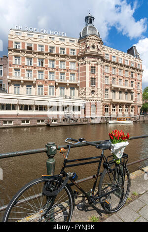 NH Doelen Hotel, Fahrrad mit Tulpen, Amsterdam, Niederlande Stockfoto