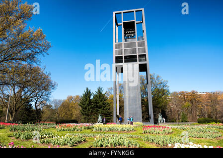 ARLINGTON, Virginia, USA – im Vordergrund des niederländischen Carillon im Arlington Ridge Park blühen leuchtende Tulpen. Der 127 Meter hohe offene Stahlturm mit 50 Bronzeglocken erhebt sich hinter einer bunten Palette niederländischer Tulpen. Diese Frühlingsschau umgibt das 1954 von den Niederlanden geschenkte Denkmal und bietet einen malerischen Blick auf die Skyline von Washington, DC, die in der Ferne über den Potomac River sichtbar ist. Stockfoto