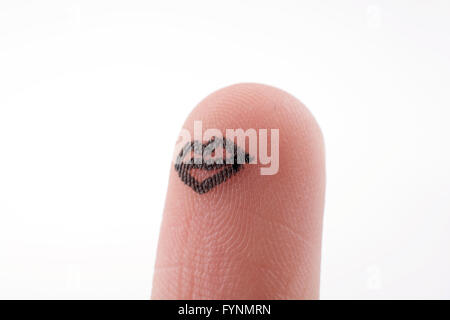 Lippen auf eine Fingerspitze mit schwarzer Farbe gezeichnet Stockfoto
