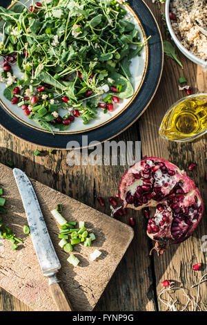 Grüner Salat mit Granatapfel, Manna Kruppe, Zwiebeln. Granatapfel-Dressing. Stockfoto