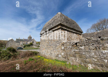 Penmon Dovecot, Wales. Malerische Aussicht auf den Anfang des 17. Jahrhunderts Penmon Dovecot, mit Penmon Priory im Hintergrund. Stockfoto