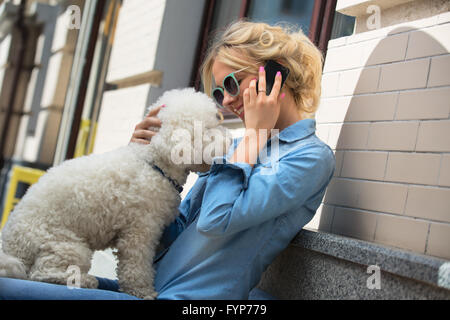 Süße Blondine mit weißen Bichon Frise Hund Stockfoto