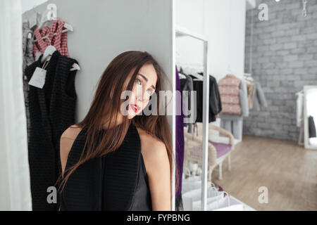 Nachdenkliche Frau im Bekleidungsgeschäft Stockfoto