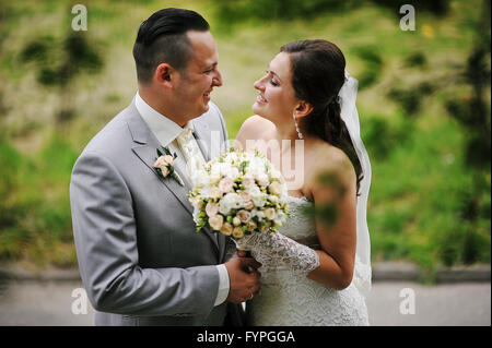 Hochzeitspaar in Liebe zu Fuß in den park Stockfoto