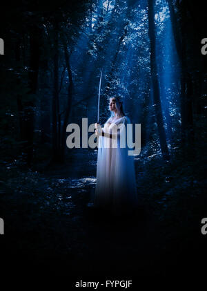 Jungen Elfen Mädchen mit Schwert im nächtlichen Wald Stockfoto