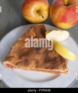 Apfelkuchen und Apfel auf einem Holztisch. Stockfoto