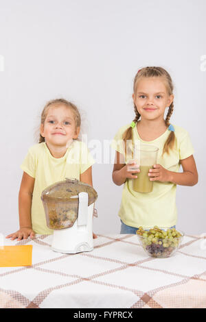 Zwei Mädchen gepresster Fruchtsaft in einem Entsafter Stockfoto