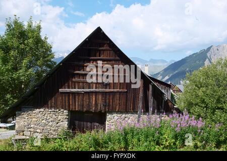 Alte baufällige Scheune gemacht von Geröll und Holz, befindet sich im Albiez Montrond in den französischen Alpen. Berggipfel sieht man in den Rücken Stockfoto