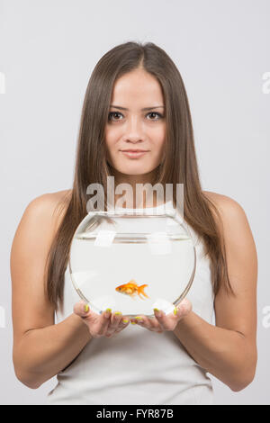 Fröhliche junge Mädchen mit einem Aquarium mit Goldfischen in Händen Stockfoto