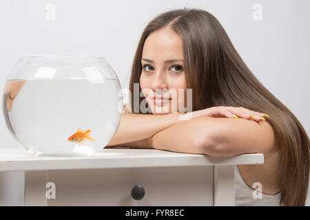 Sie dachte die kleine Goldfische in einem Aquarium beobachten Stockfoto