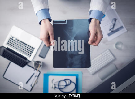 Radiologe Cheching ein Röntgenbild der menschlichen Wirbelsäule, Hände hautnah mit Desktop Hintergrund, Ansicht von oben Stockfoto