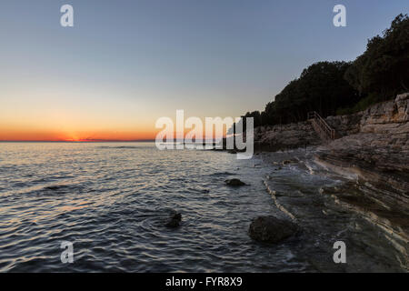 Sonnenuntergang, Felsiger Strand in Istrien, Kroatien. Solaris Sommer Resort, Adria, Lanterna Halbinsel. Stockfoto