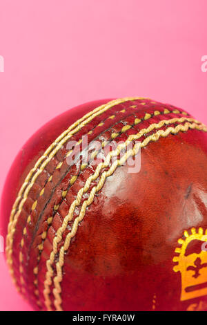 Cricketball auf rosa Hintergrund Stockfoto