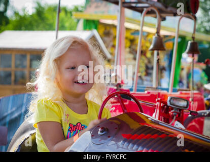 Das Kind geht für eine Fahrt auf einem Kinder-Attraktion Stockfoto