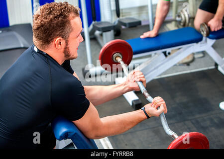 Mann, der seine Arme und Brust im Fitness-Studio arbeitet. Stockfoto