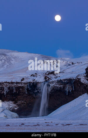 Seljalandsfoss, 66 m hohe Wasserfall liegt am Fluss Seljalandsá in der Nacht im Winter Rangárþing Eystra, Island Stockfoto