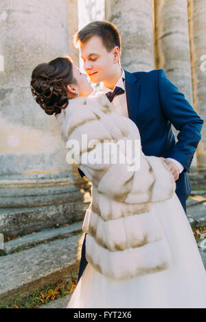 Awesome Hochzeitspaar auf der Suche in jedem anderen Hintergrund Spalten der alten Burg Kirche Stockfoto