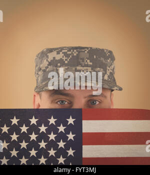 Militär Armee Soldat hält eine amerikanische Flagge bis zu seinem Gesicht mit einer einheitlichen auf und Exemplar für ein Veteran, Denkmal oder er Stockfoto