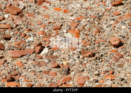 Schuss von einem sandigen, steinigen Pfad mit zahlreichen Stücke des gebrochenen Ziegel eingebettet an einem sonnigen Sommertag hautnah. Stockfoto