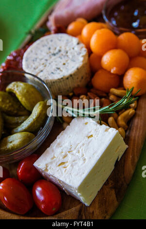 Käseplatte, Antipasti Teller marinierte Oliven mit Frischkäse, getrockneten Tomaten, Prosciutto. Stockfoto