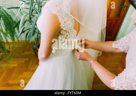 Mutter hilft der Braut - ihre Tochter zur Hochzeitskleid anziehen, Nahaufnahme Foto Stockfoto