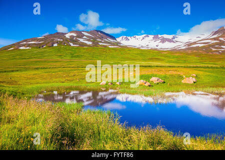 Blauen Seewasser spiegelt die verschneiten Hügel Stockfoto