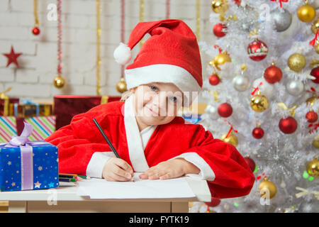 Das Mädchen schrieb an Santa Claus Wunschliste Stockfoto