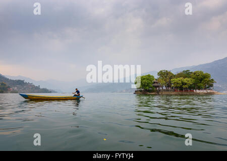 Nepalesische Mann paddeln am Phewa-See in Pokhara, Nepal Stockfoto