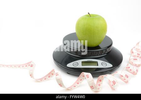 Schwarzen Digitalwaage auf isolieren weißen Hintergrund, mit grünem Apfel, Maßband Stockfoto